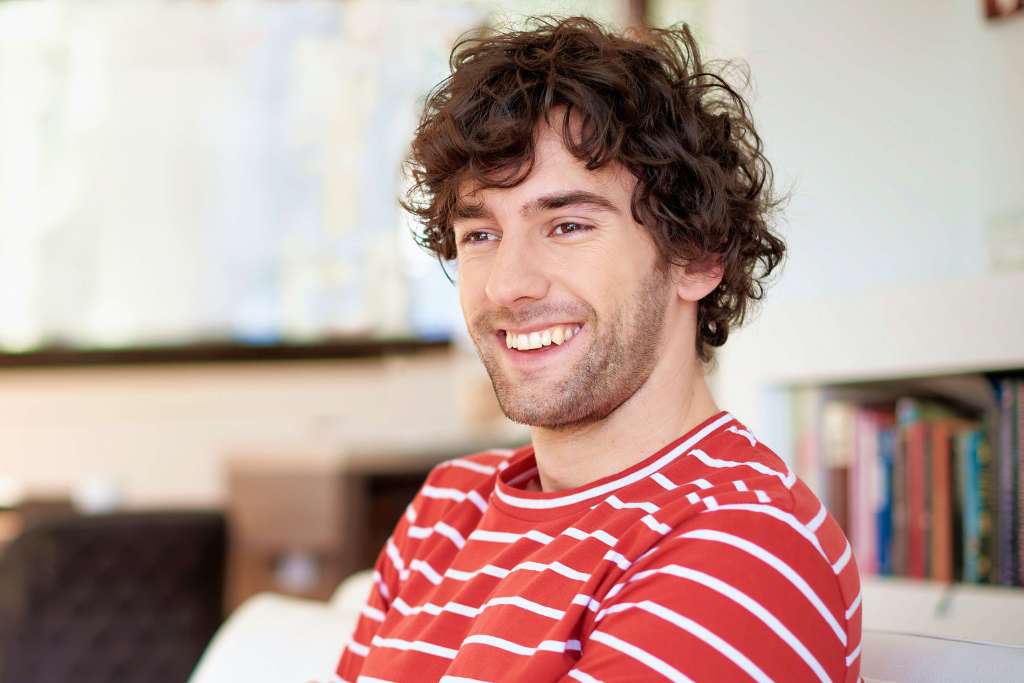 Man smiling while sitting indoors